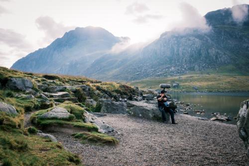 Sound recordist on a mountain by a lake in Wales, UK film making